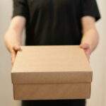 a person in black shirt holding a box