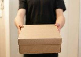 a person in black shirt holding a box