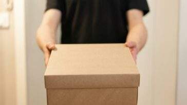 a person in black shirt holding a box