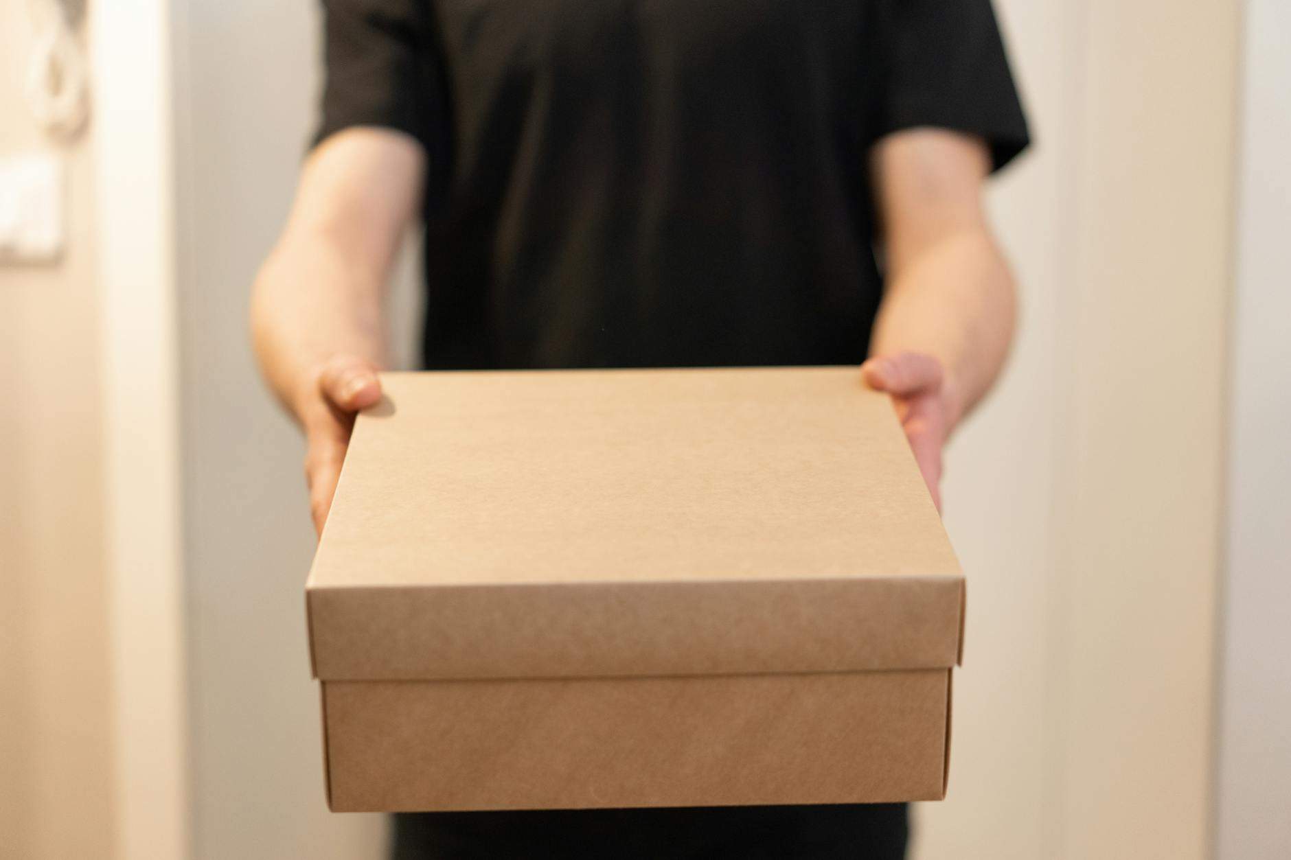 a person in black shirt holding a box