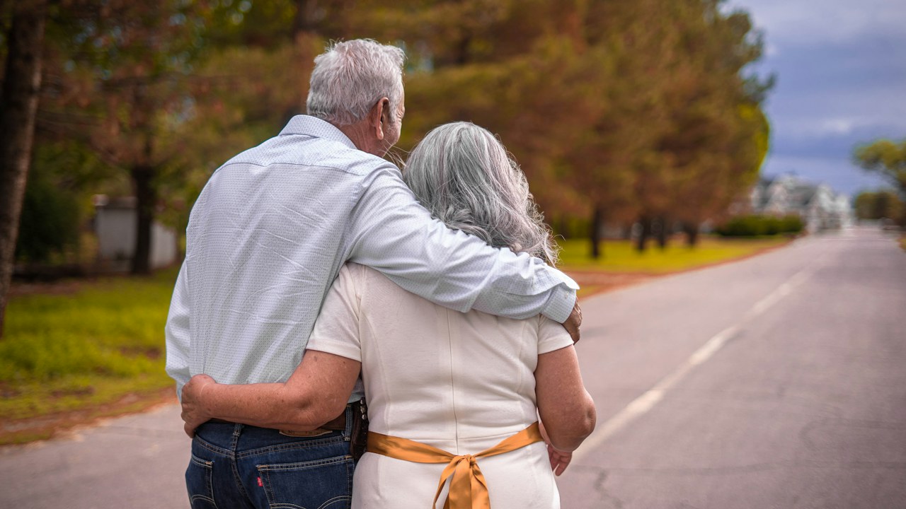 Un couple vu de dos marche côte à côte. Photographie d’illustration, sans lien avec les personnels cités dans le dossier.