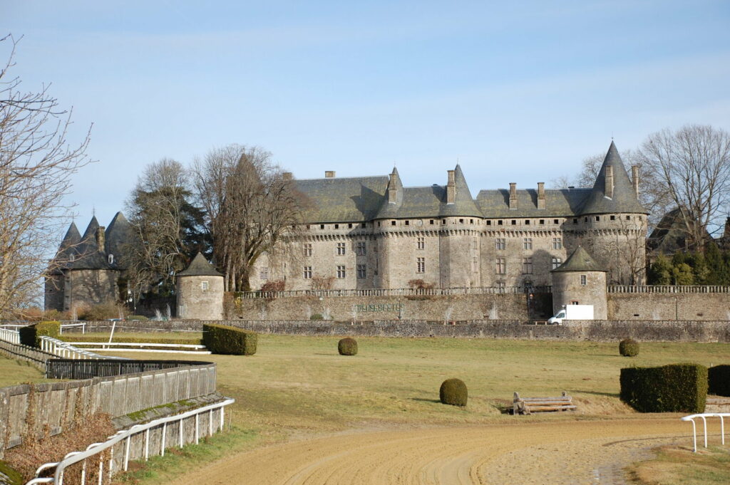 Château de Pompadour vu depuis l’hippodrome, avec la piste au premier plan.