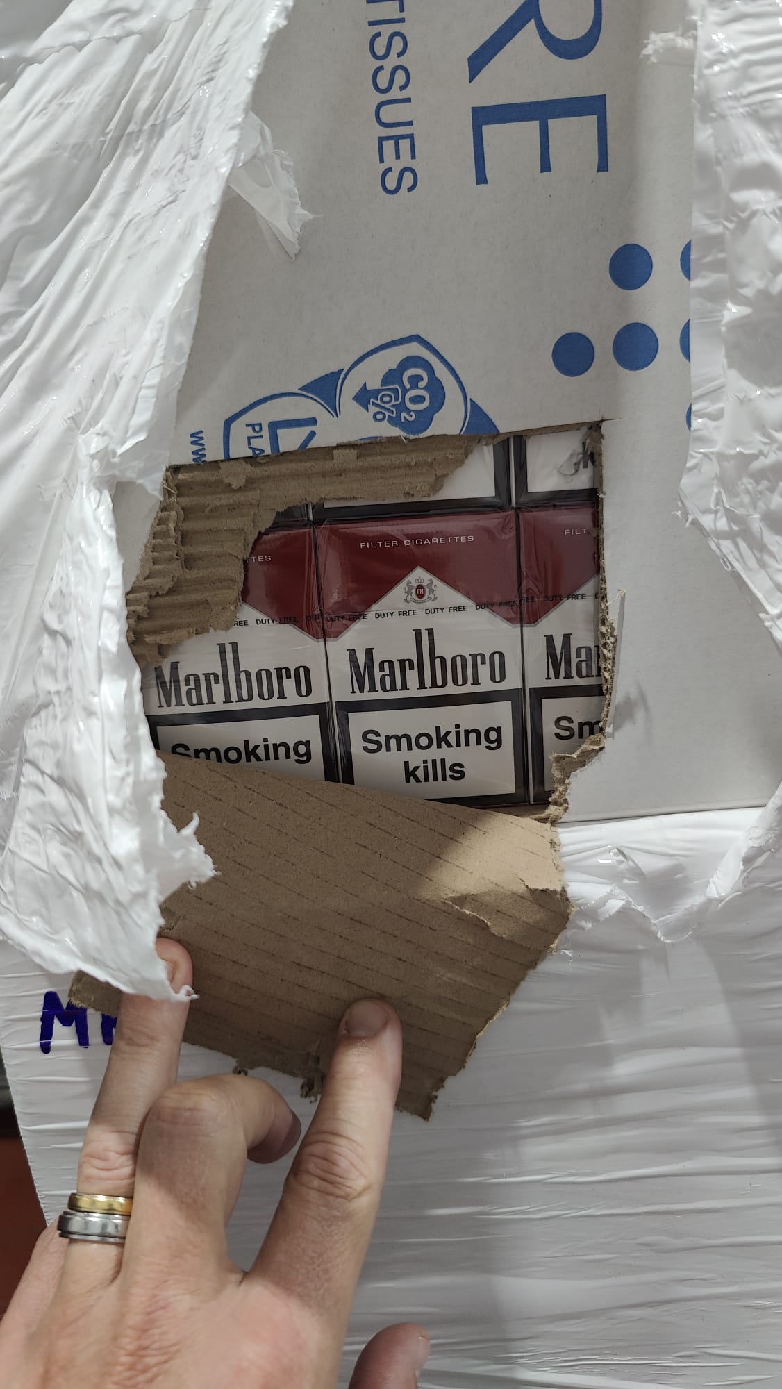 Ouverture d’un carton laissant apparaître des paquets de cigarettes dans la cargaison saisie par les gendarmes et la DNRED