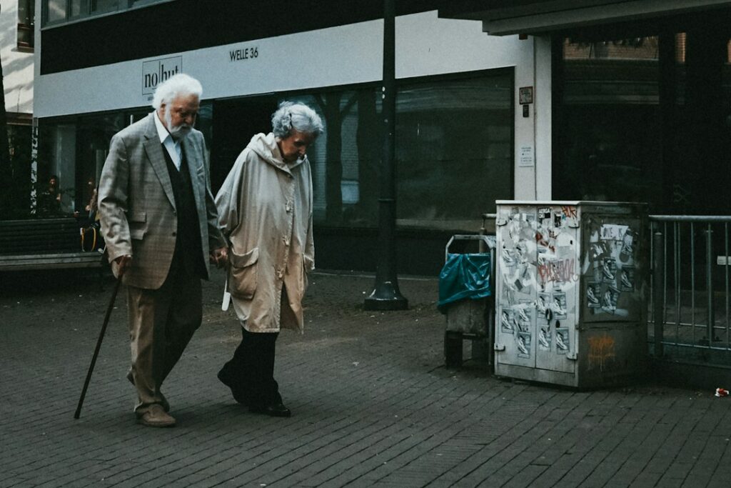 Seniors dans l’Hérault : où demander de l’aide pour rester chez soi ? Deux personnes âgées marchent dans une rue, photographie d’illustration.