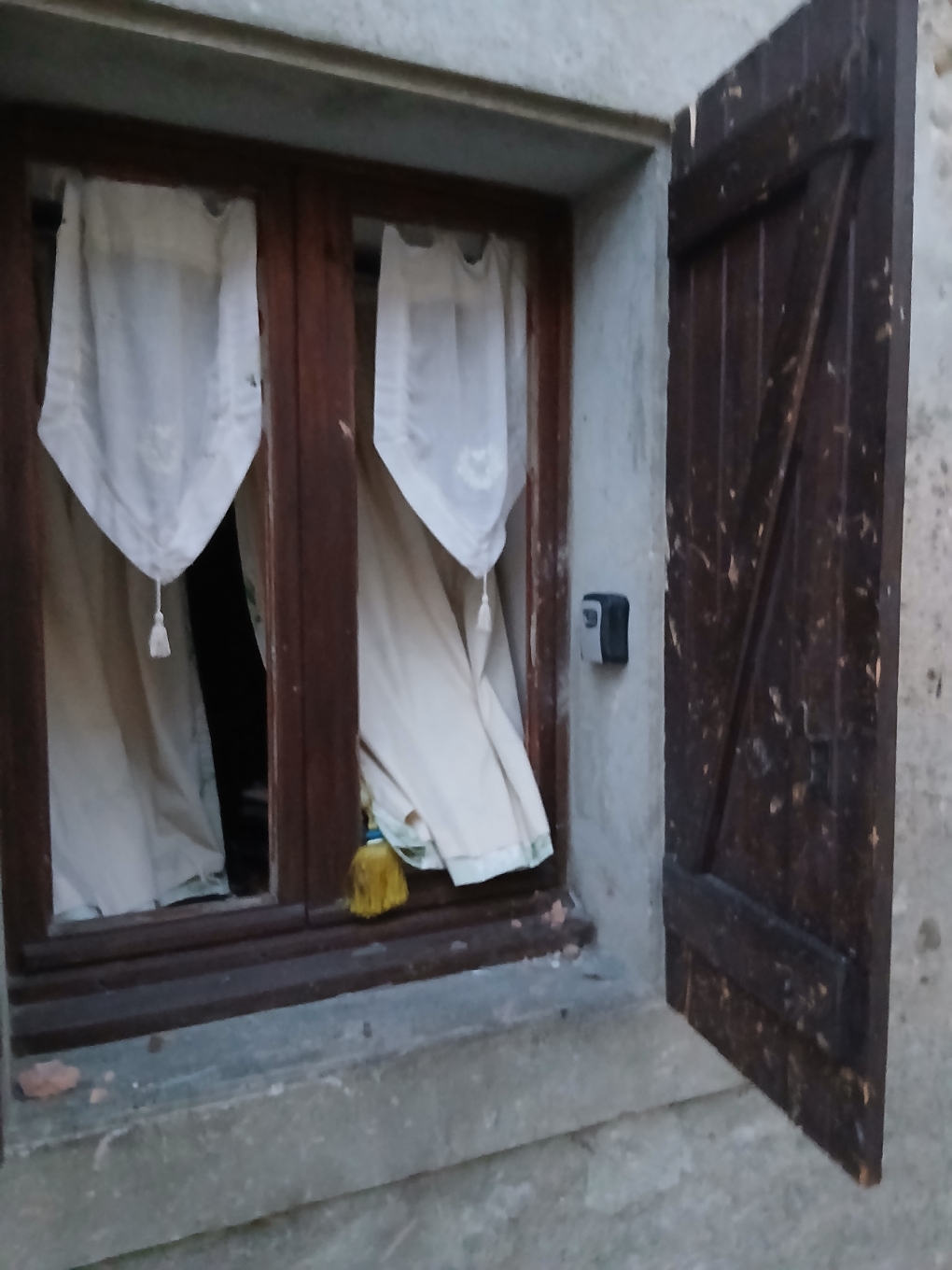 Une fenêtre aux vitres brisées et un volet marqué par les impacts après la tornade à Pomas.
