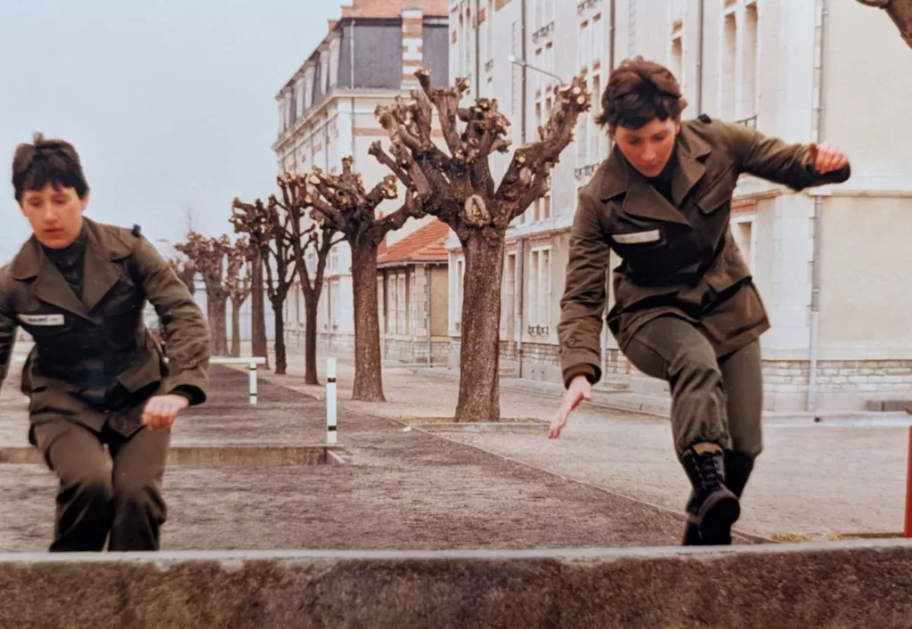 Deux élèves en uniforme franchissent un obstacle lors d’un exercice de formation.